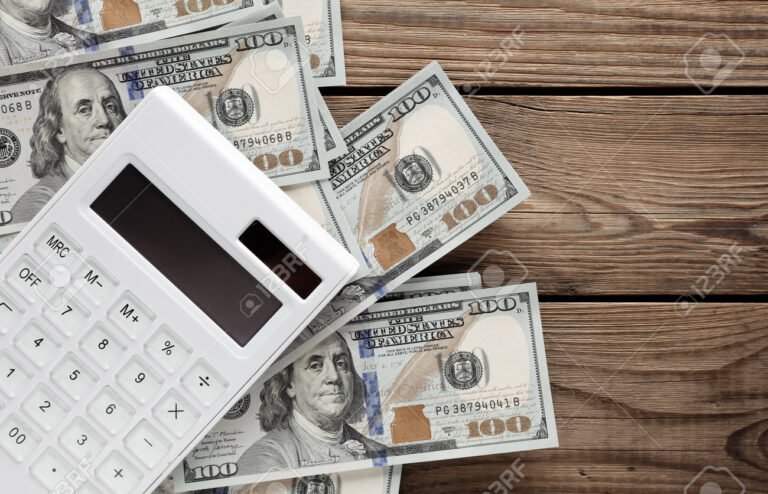 billetes y calculadora sobre mesa madera