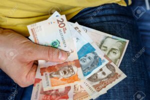 manos sosteniendo monedas y billetes variados